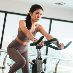 Mulher pedalando em uma Bike Spinning