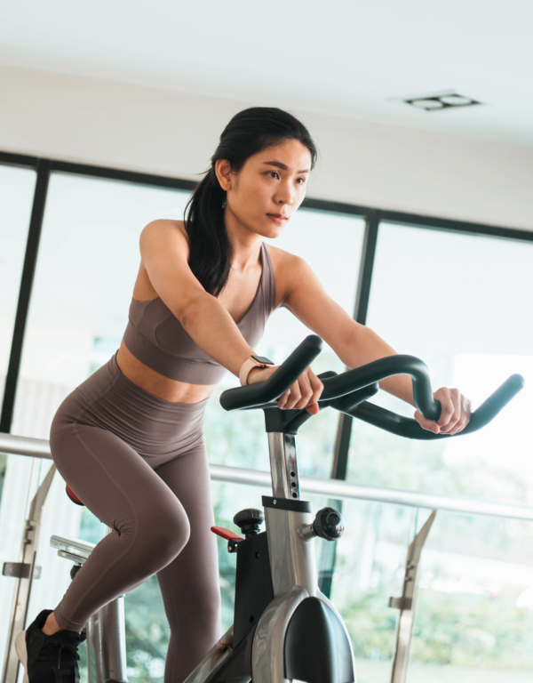 Mulher pedalando em uma Bike Spinning