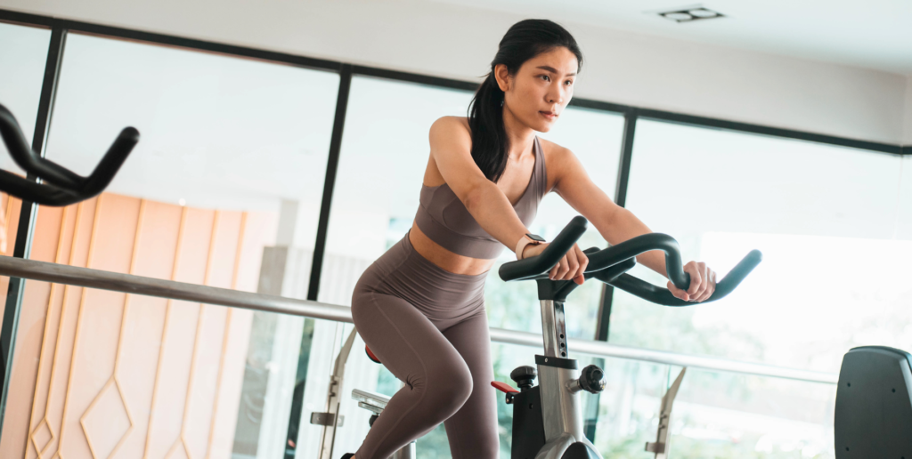 Mulher pedalando em uma Bike Spinning