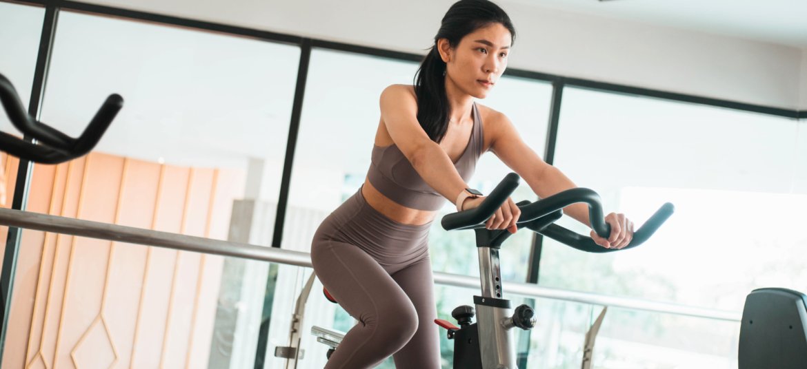 Mulher pedalando em uma Bike Spinning