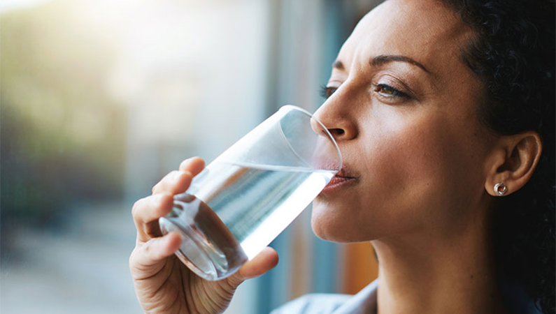 Mulher bebendo agua com habitos saudaveis para emagrecer